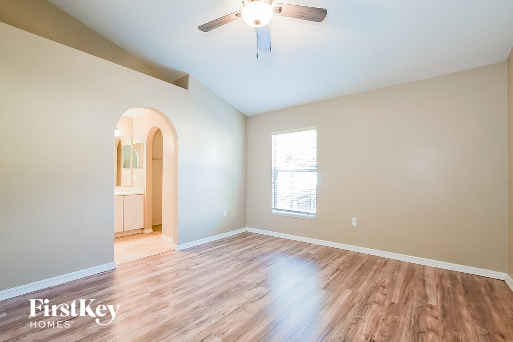 A room with wooden flooring and a ceiling fan.