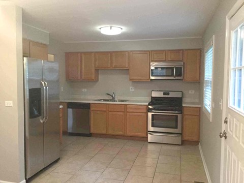 a kitchen with wooden cabinets and stainless steel appliances