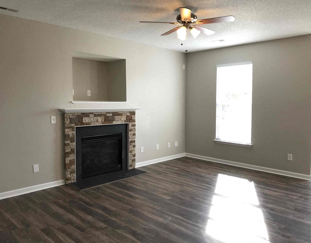 A room with a fireplace and a ceiling fan.