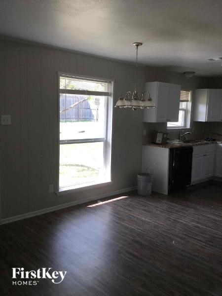 A kitchen with a view of a backyard through a window.