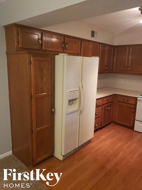 A kitchen with wooden cabinets and a white refrigerator.