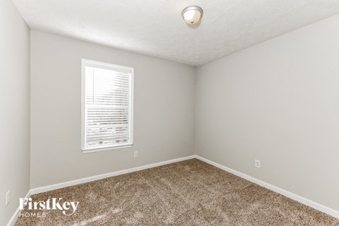 a bedroom with carpet and a window