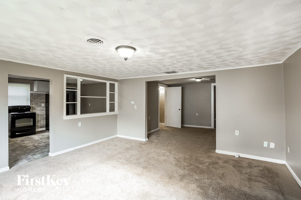 a living room with carpet and a white ceiling