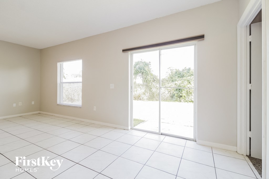 an empty living room with sliding glass doors to the backyard