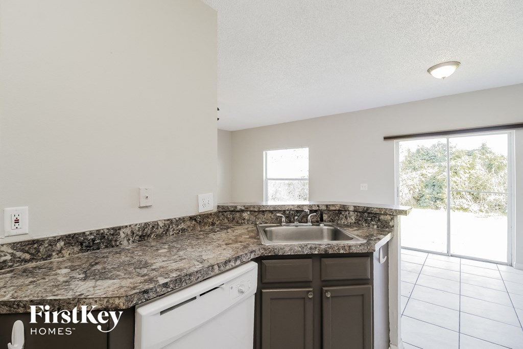 an updated kitchen with granite counter tops and a sink