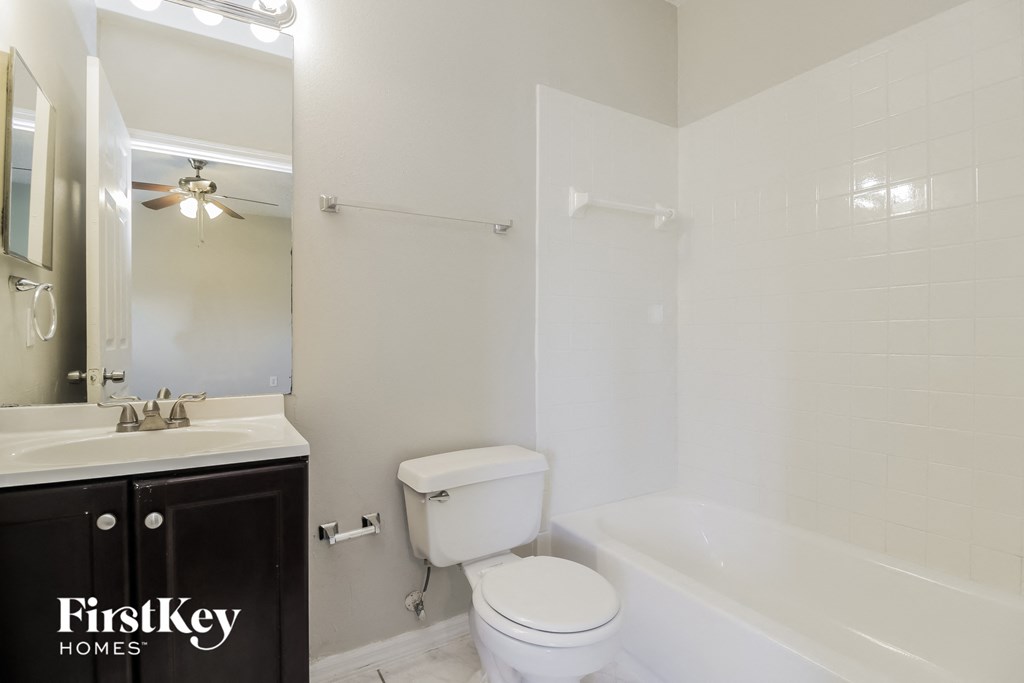a bathroom with a toilet and a tub and a sink
