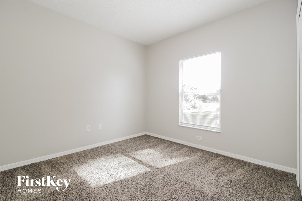 a bedroom with carpet and a window
