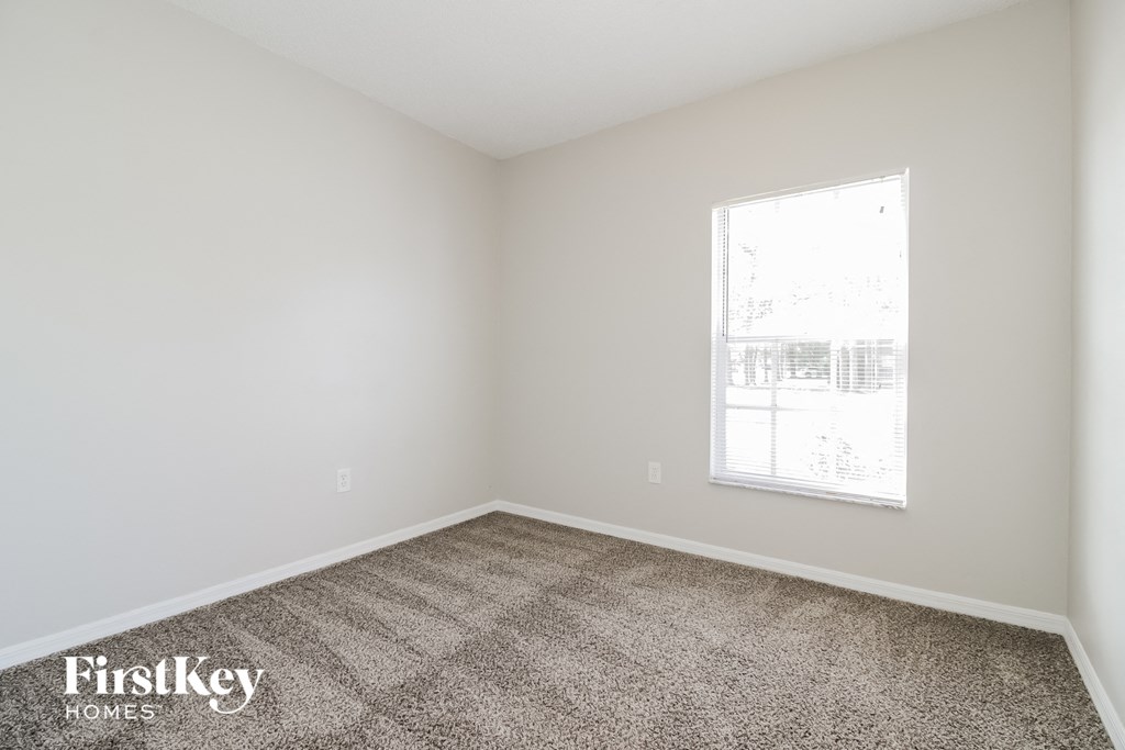 an empty room with carpet and a window