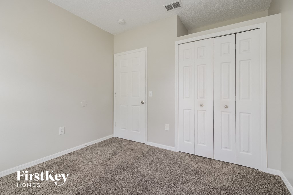 a bedroom with two closets and a carpeted floor