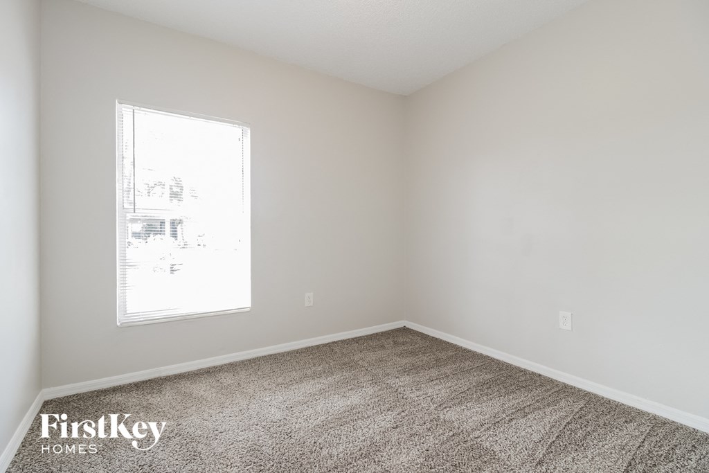 an empty room with carpet and a window