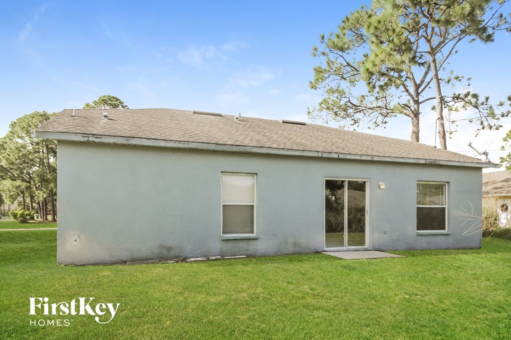 a small white house with a lawn and a tree
