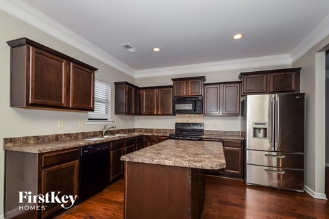 a kitchen with dark wood cabinets and granite counter tops and stainless steel appliances