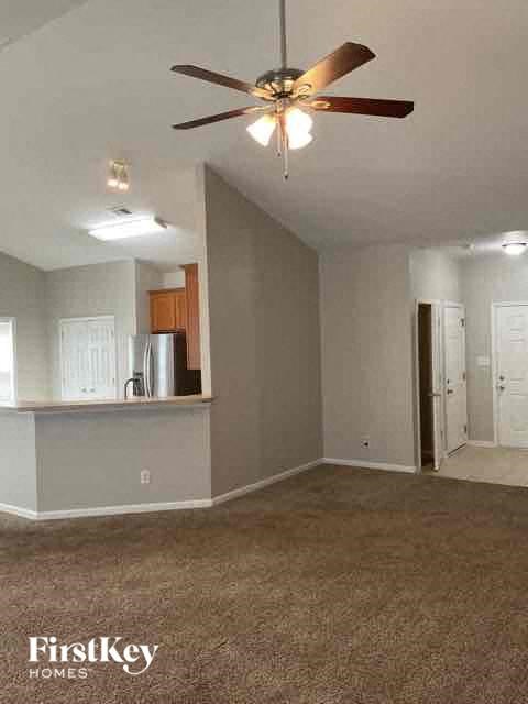 A room with a ceiling fan and a carpeted floor.