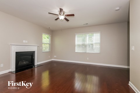 a living room with a ceiling fan and a fireplace