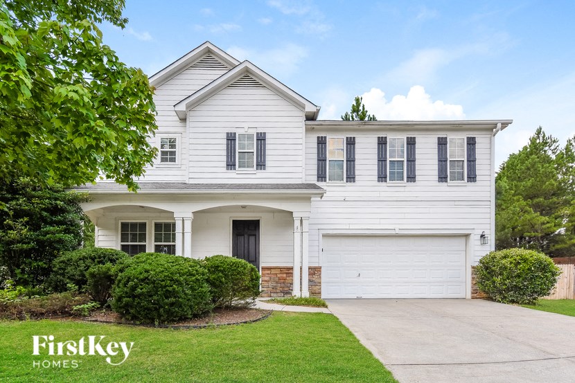 a white house with black shutters and a driveway