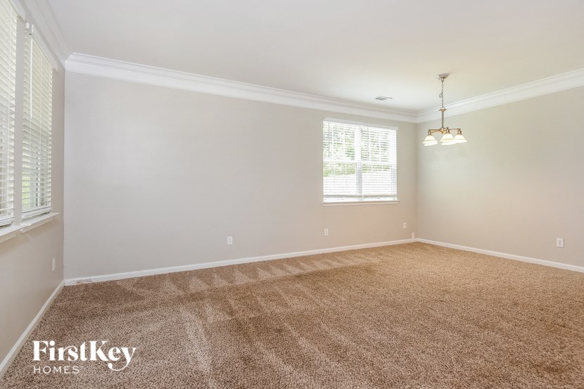 an empty living room with carpet and a window