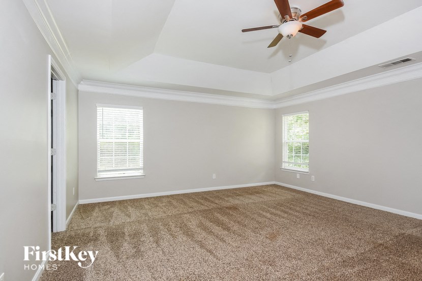 an empty living room with a ceiling fan