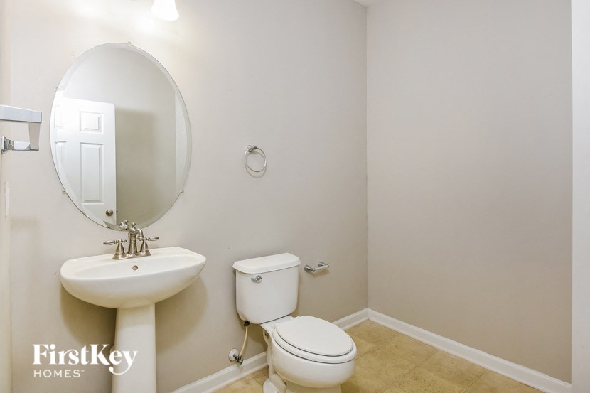 a bathroom with a toilet and a sink and a mirror