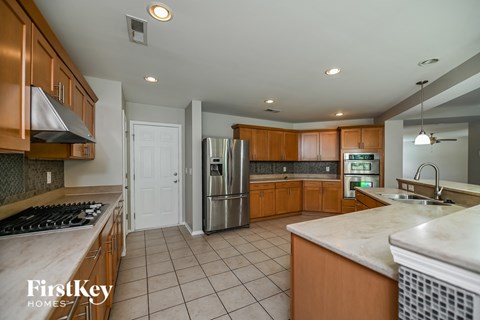 A kitchen with wooden cabinets and a stainless steel refrigerator.