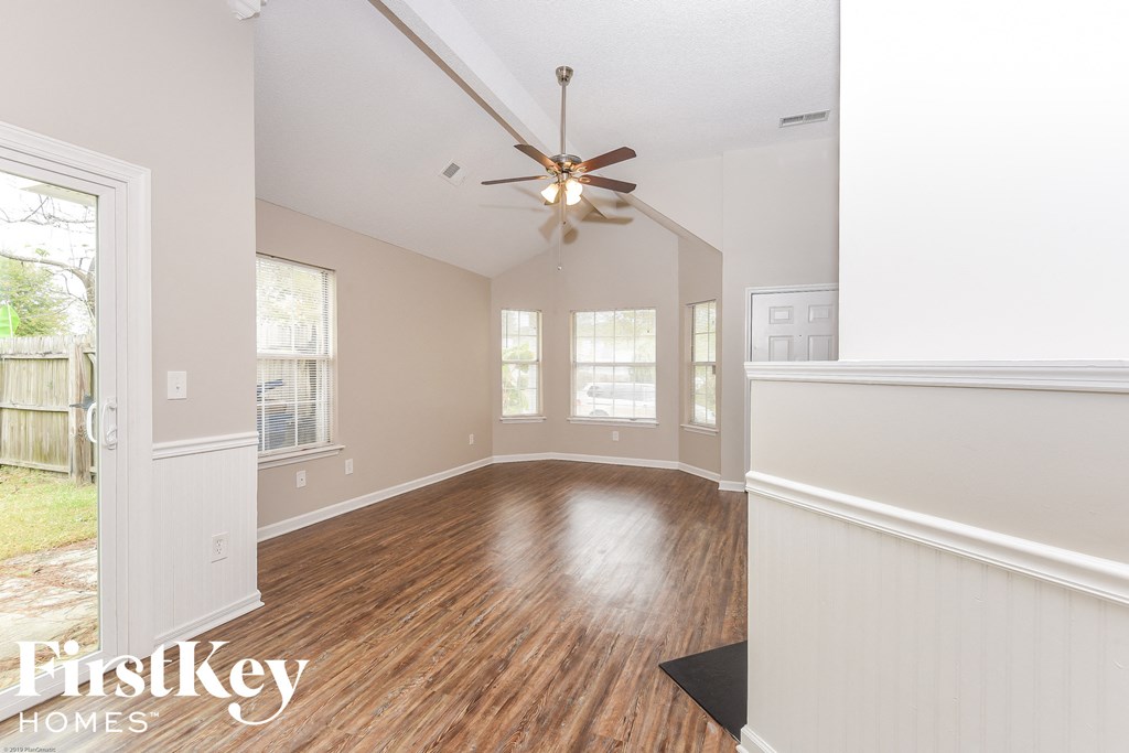 A room with wooden floors and a ceiling fan.