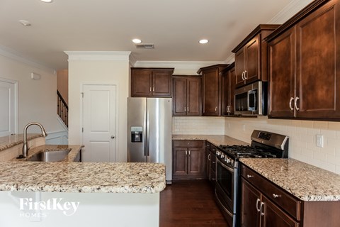 a kitchen with wooden cabinets and granite counter tops and stainless steel appliances