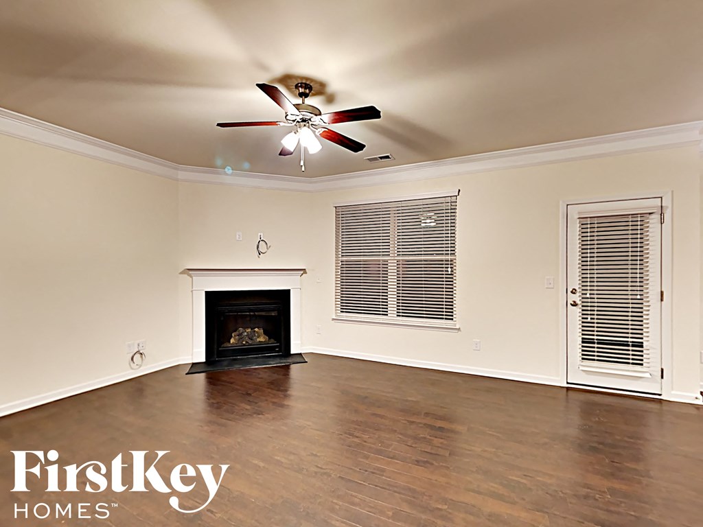 A room with a fireplace and a ceiling fan.