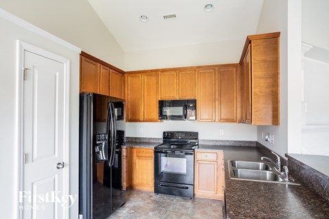 a kitchen with wooden cabinets and black appliances