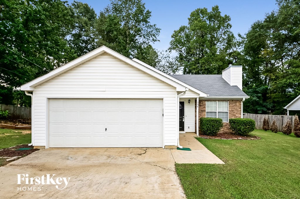 A white house with a garage door and a chimney.