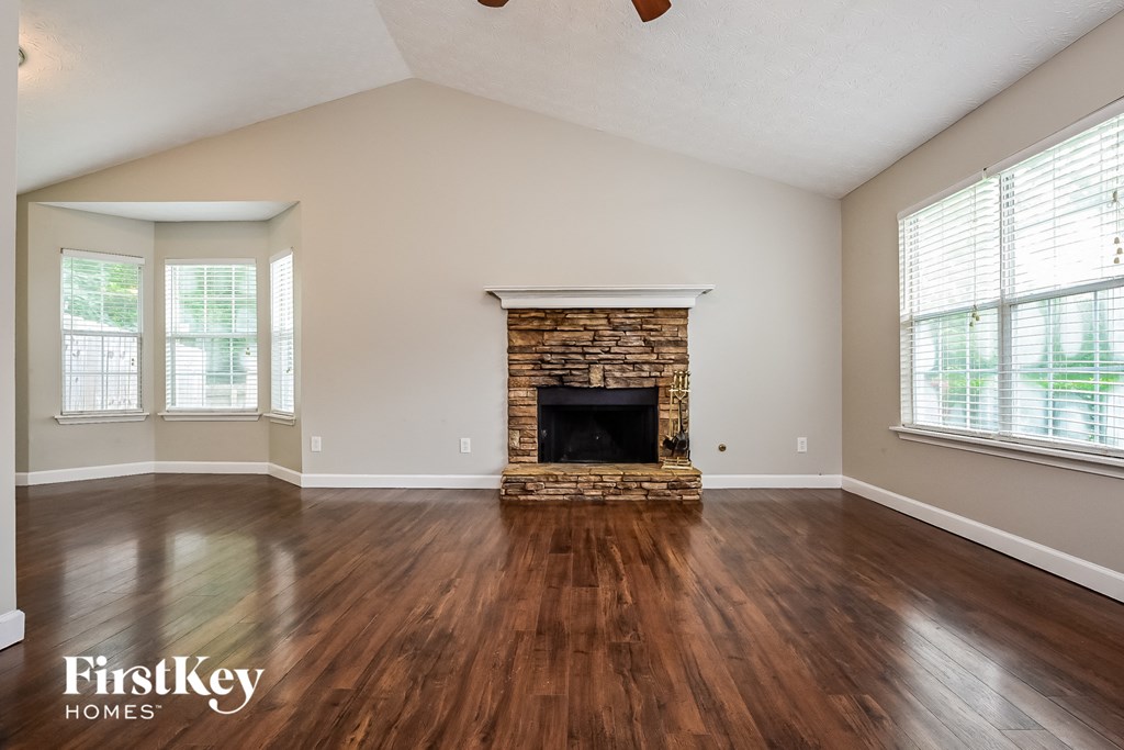 A living room with a fireplace and wood flooring.