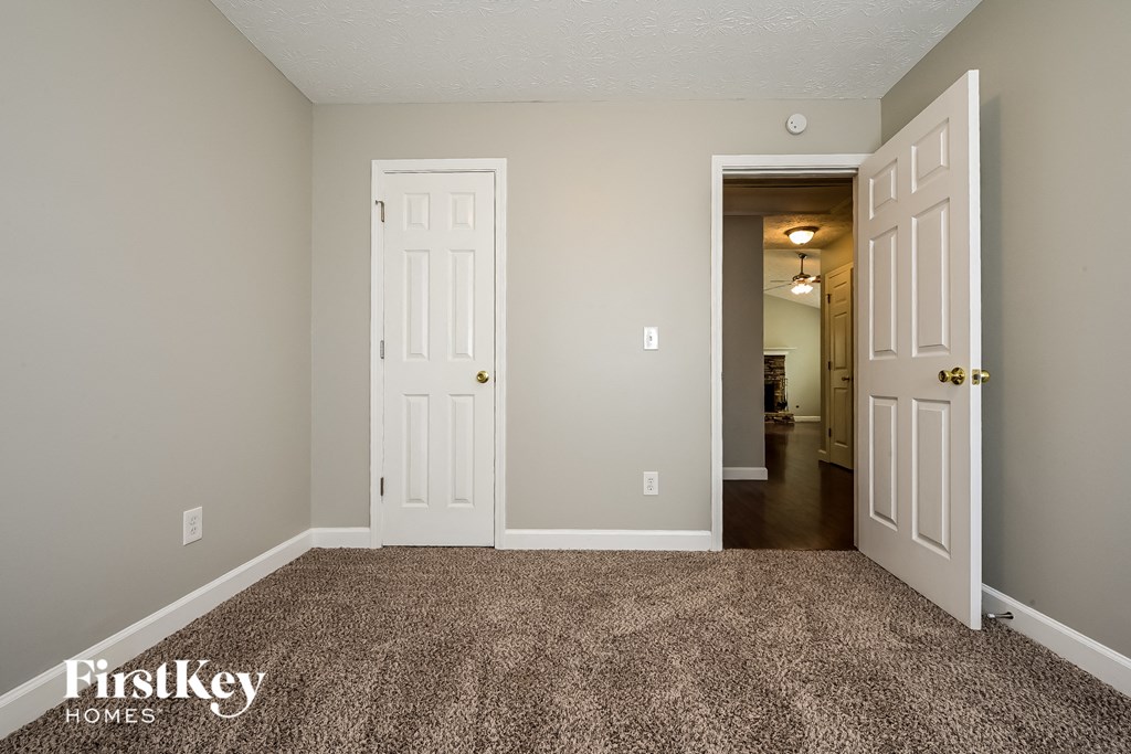 A room with two white doors and a carpeted floor.