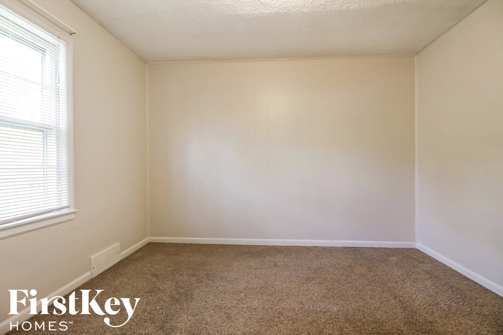 a empty room with a carpeted floor and a window