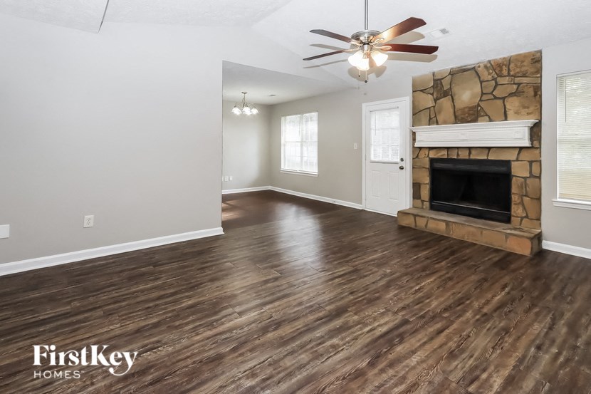 the living room with wood flooring and a fireplace
