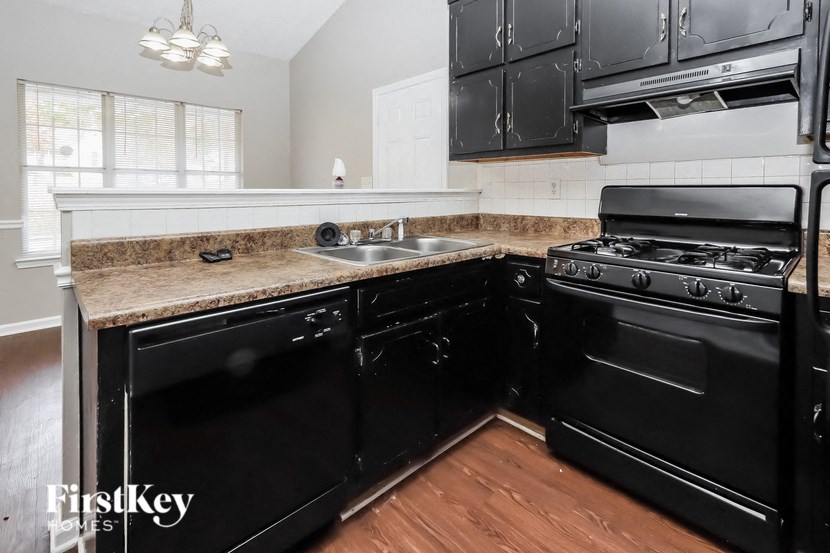 a kitchen with black appliances and granite counter tops and black cabinets