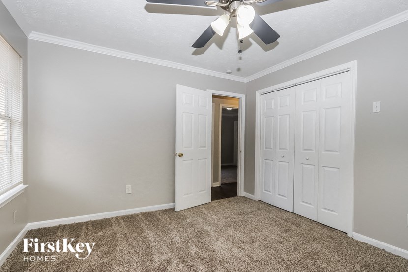 a bedroom with two closets and a ceiling fan