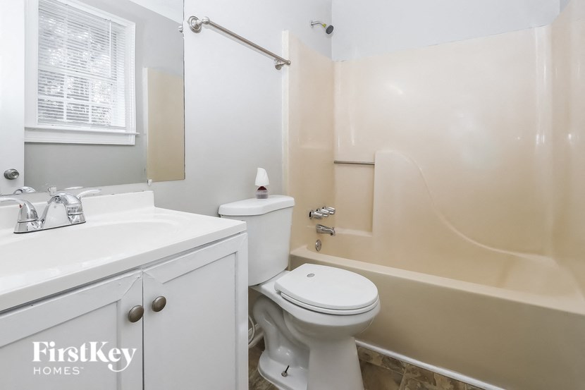 a bathroom with a toilet and a sink and a bath tub