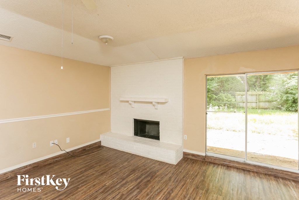a living room with a fireplace and a wooden floor