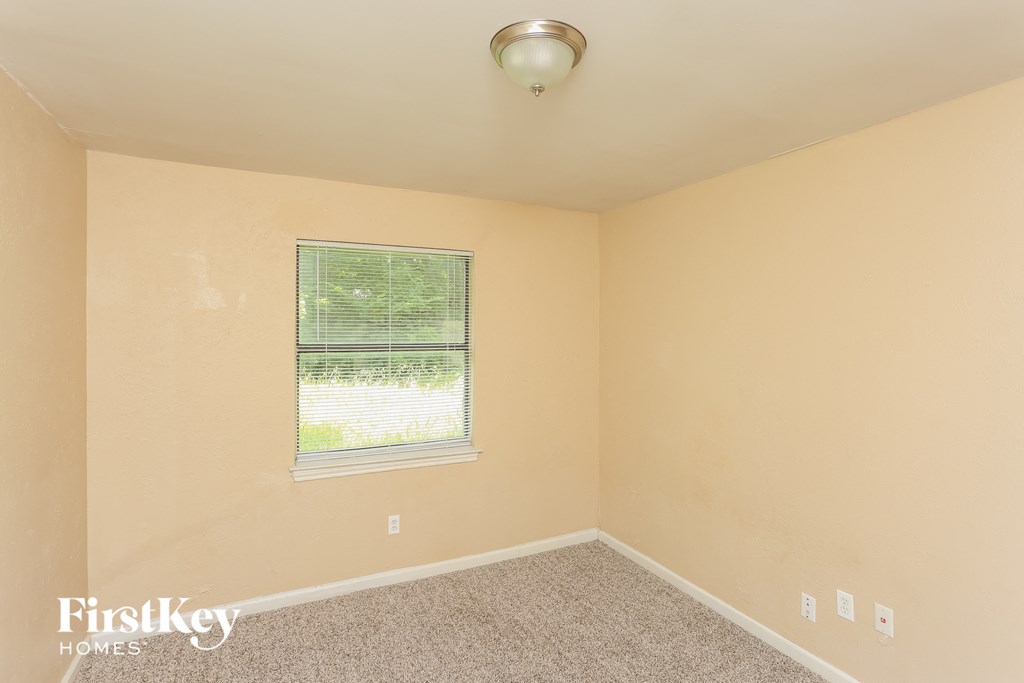 the living room of a home with a window and carpet