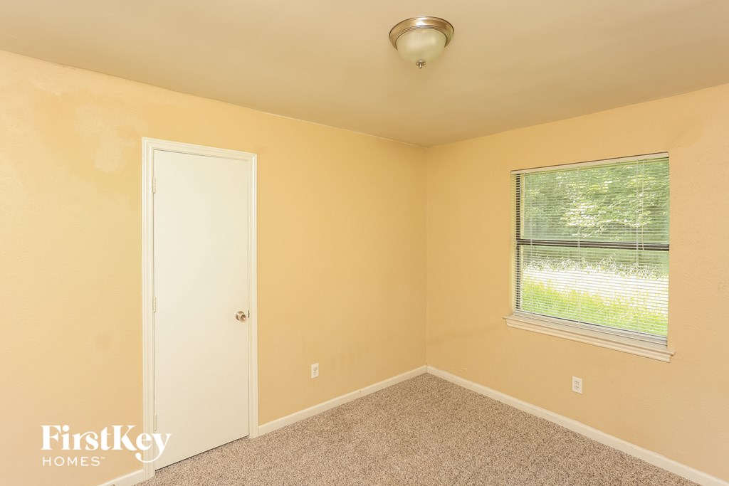 the bedroom of a home with a door and a window