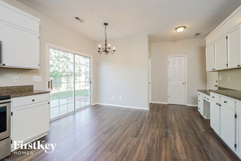 A kitchen with white cabinets and a brown countertop.