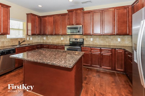 a kitchen with cherry wood cabinets and granite counter tops