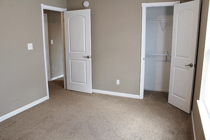 an empty room with two doors and a closet