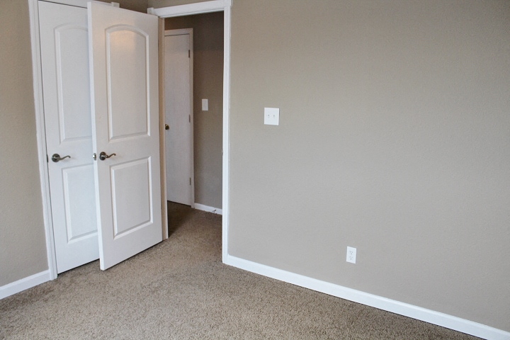 an empty room with two doors and a hallway