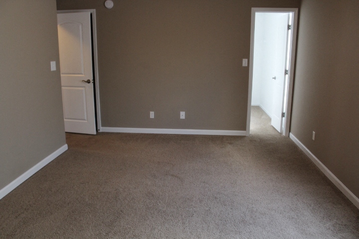 an empty room with a carpeted floor and a door