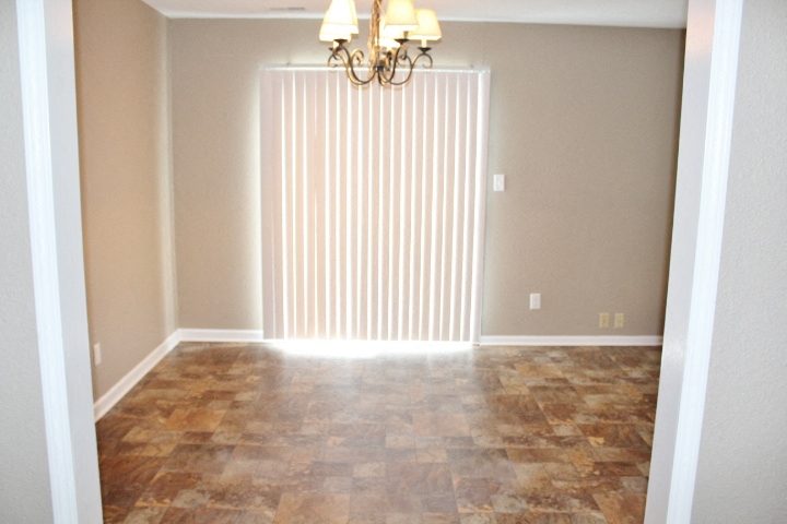 an empty living room with a large window and a curtain