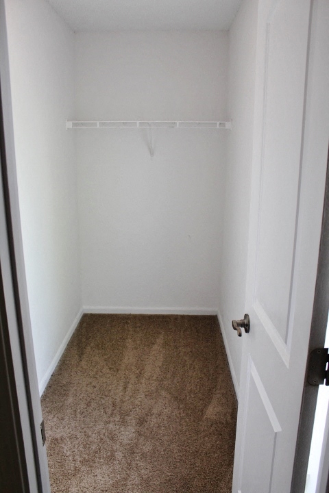 a small room with a carpeted floor and a white closet