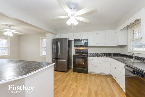 A kitchen with a refrigerator, oven, and microwave.