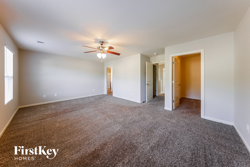 a living room with carpet and a ceiling fan