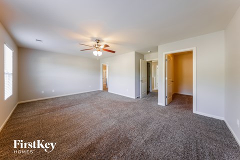 a living room with carpet and a ceiling fan