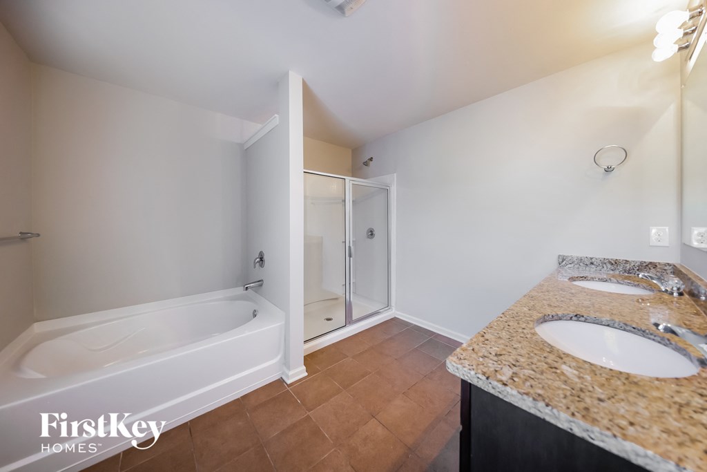 a bathroom with two sinks and a tub and a shower
