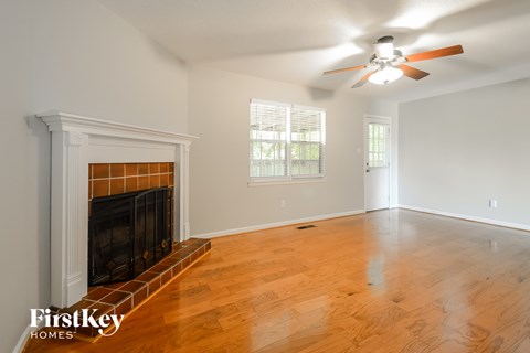 a living room with a fireplace and a ceiling fan